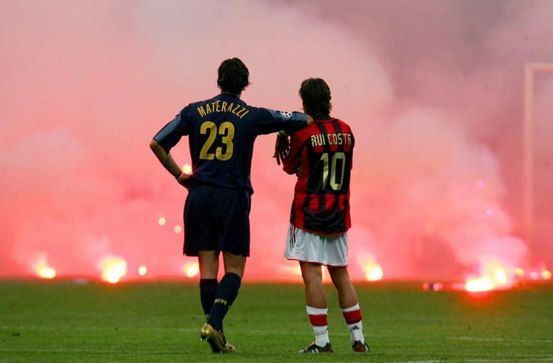 Inter Milan's Materazzi and Rui Costa of AC Milan wait on the pitch during their Champions League soccer match in Milan